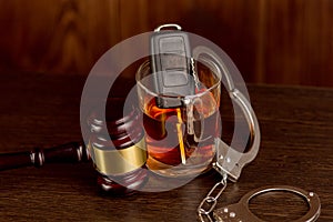 Whiskey with car keys and handcuffs. Concept for drinking and driving