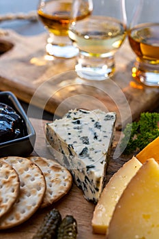 Whiskey and cheese pairing, tasting whisky glasses and plate with sliced cheeses