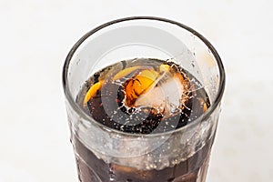 whiskey cocktail with cola and ice in a transparent glass with splashes