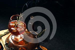 Whiskey cocktail with ice and burnt rosemary