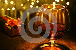 Whiskey, cognac, brandy and gift box on wooden table. Celebration composition on the light background.