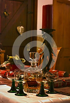 A whiskey decanter with glasses on a festively decorated table