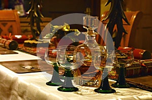 A whiskey decanter with glasses on a festively decorated table