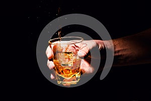 Whiskey glass in a hand of a man