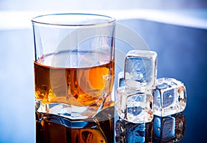 Whiskey in glass with ice cubes