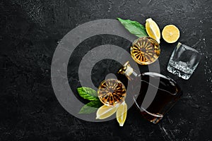 Whiskey in glasses on black stone table.