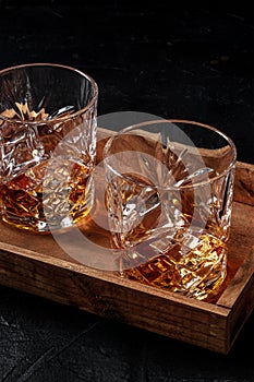 Whiskey with ice. Bourbon whisky on rocks on a dark wooden table