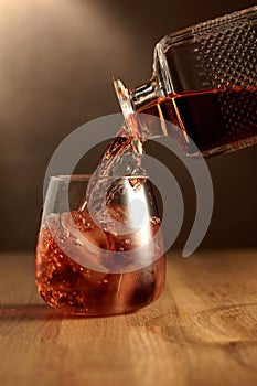 Whiskey is poured into a dammed glass with ice