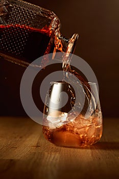 Whiskey is poured into a dammed glass with ice