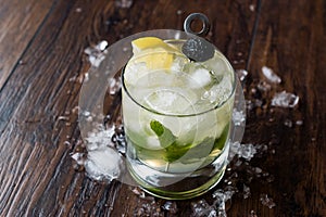 Whiskey Smash Cocktail with Mint Leaves, Lemon, Olive and Crushed Ice.