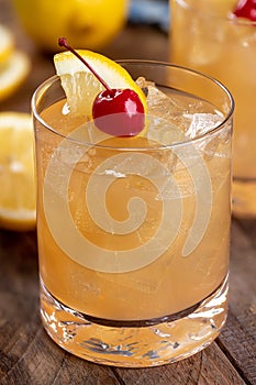 Whiskey sour cocktail with cherry and lemon