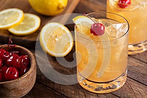 Whiskey sour cocktail with cherry and lemon photo