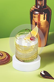 Whiskey sour trendy alcoholic cocktail with bourbon, lemon juice, egg white and ice in glass on bright green background, hard