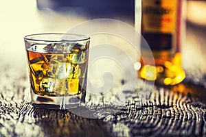 Whiskey. Whiskey drink with ice cubes on old rustic oak table