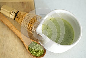 Whisking green Japanese Matcha powder in chawan with chasen