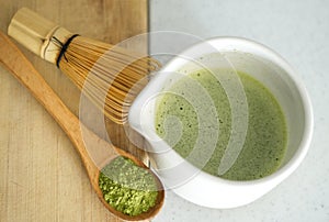 Whisking green Japanese Matcha powder in chawan with chasen