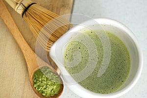 Whisking green Japanese Matcha powder in chawan with chasen