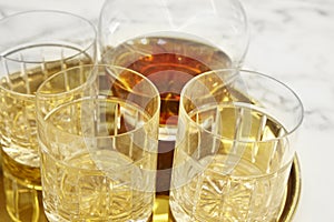 Whisky bottle detail with classic glasses on a tray