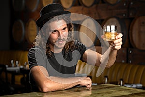 Whisky glass cheers stylish man drinking bourbon at a whiskey distillery restaurant bar