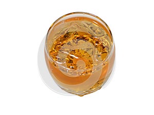 Whisky in a glass with ice pieces the top view on a white background