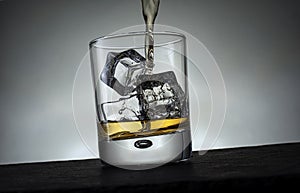 Whisky Pouring into a Glass with Ice