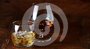 Whisky on the rocks and cognac in a snifter photo