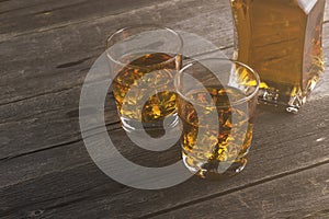 Whisky in two glasses on a dark wooden background. Toning
