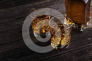 Whisky in two glasses on a dark wooden background. Toning