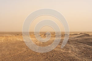 Whisps Of Sand Blow Over The Barren Desert Floor