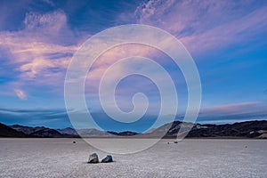 Whispy Clouds Tower Over The Racetrack Playa At Sunset