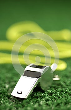 Whistle laying on green astroturf