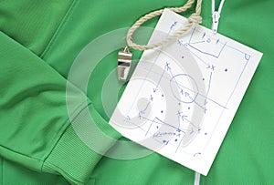 Whistle of a soccer or football referee or coach and a tactical diagram scribble on a track suit