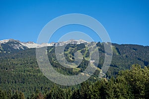 Whistler Mountain in British Columbia, Canada in the summer sun and blue sky looking at sky lift and runs used for mountain biking