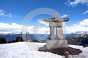 Whistler Peak inukshuk with snow and mountains photo