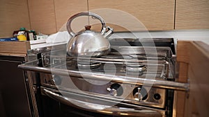 Whistling kettle on gimballed gas stove in sailing yacht during yachting