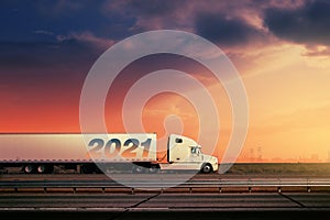 White 2021 truck on freeway road under sunset sky