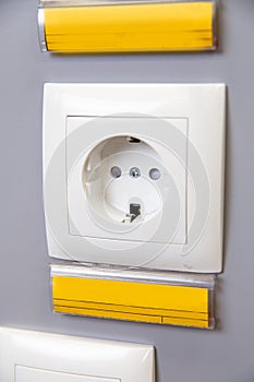 a white 220 volt outlet on a gray wall