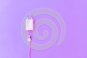 White Ñable phone chargers on pink background. Top view. Objects on a simple background