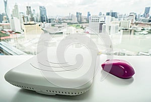 White access point with purple mouse on office desk