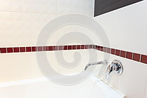 White acrylic bathtub with built-in wall mixer