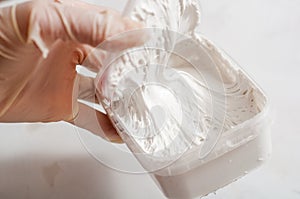 White acrylic glazing putty for wood and metal interior and exterior use on a putty knife showing the paste consistency