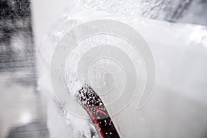 White active foam covering the paintwork of a white car