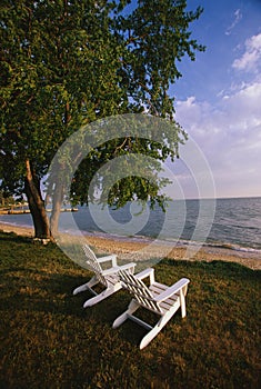 White adirondack chairs facing ocean