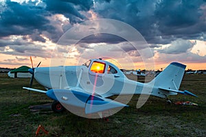 White agricultural aircraft against the backdrop of a scenic sunrise