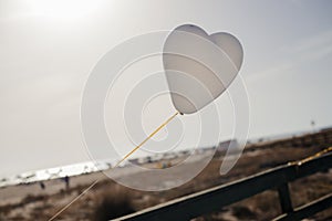 White Air Balloons heart shaped flying in blue sky. Love concept. Holiday celebration