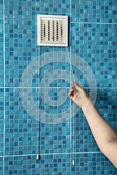 White air ventilation grille plastic cover on wall in bathroom.