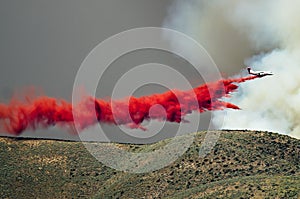 White Aircraft Dropping Fire Retardant as it Battles the Raging Wildfire