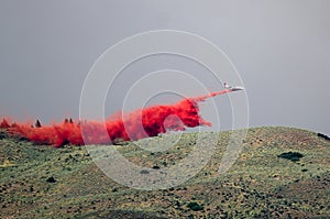 White Aircraft Dropping Fire Retardant as it Battles the Raging Wildfire