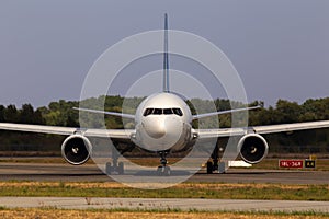 White aircraft running to the parking area, front view