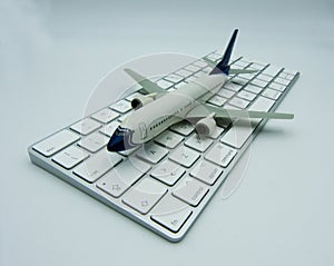 White airplane on a white computer keyboard. Aviation concept.